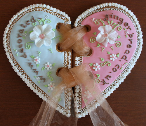 Huge gingerbread heart shaped logo with marzipan flowers and ribbon